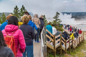 Visitors crowd the boardwalk in the Lower Geyser Basin at Yellowstone. (NPS, Neal Herbert)