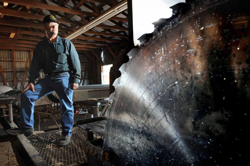 Kelly Gephardt, owner of Gephardt Post Plant & Sawmill, stands in the sawmill of his Roundup, Montana plant. (AP photo/James Woodcock, Billings Gazette.)