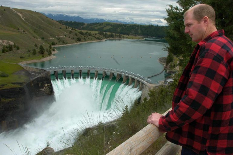 Terry McAllister looks over the Seli’š Ksanka Qlispe’ Dam on the Flathead River near Polson, Montana. (AP Photo/Daily Inter Lake, Chris Jordan)