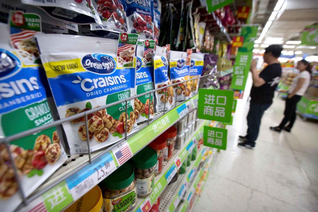 Customers shop near dried cranberry products from the United States at a supermarket in Beijing. China announced higher tariffs on $60 billion worth of American goods in retaliation for American tariffs. (AP Photo, Mark Schiefelbein)