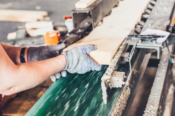 A worker processes wood at a sawmill. (Shutterstock, Vano Vasaio)