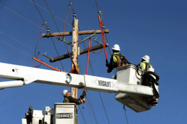 A crew from Yellowstone Valley Electric Cooperative work on a power line on Grand Avenue in Billings. (Casey Page, Billings Gazette)