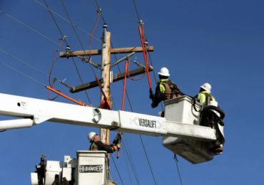 A crew from Yellowstone Valley Electric Cooperative work on a power line on Grand Avenue in Billings. (Casey Page, Billings Gazette)