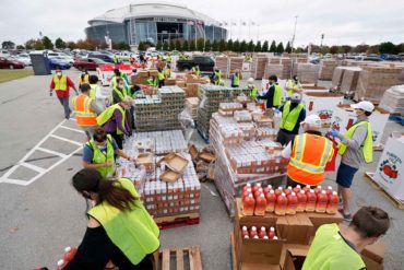 Volunteers build bags of dry goods outside AT&T Stadium during a food distribution event in Arlington, Texas. (AP Photo, Tony Gutierrez)