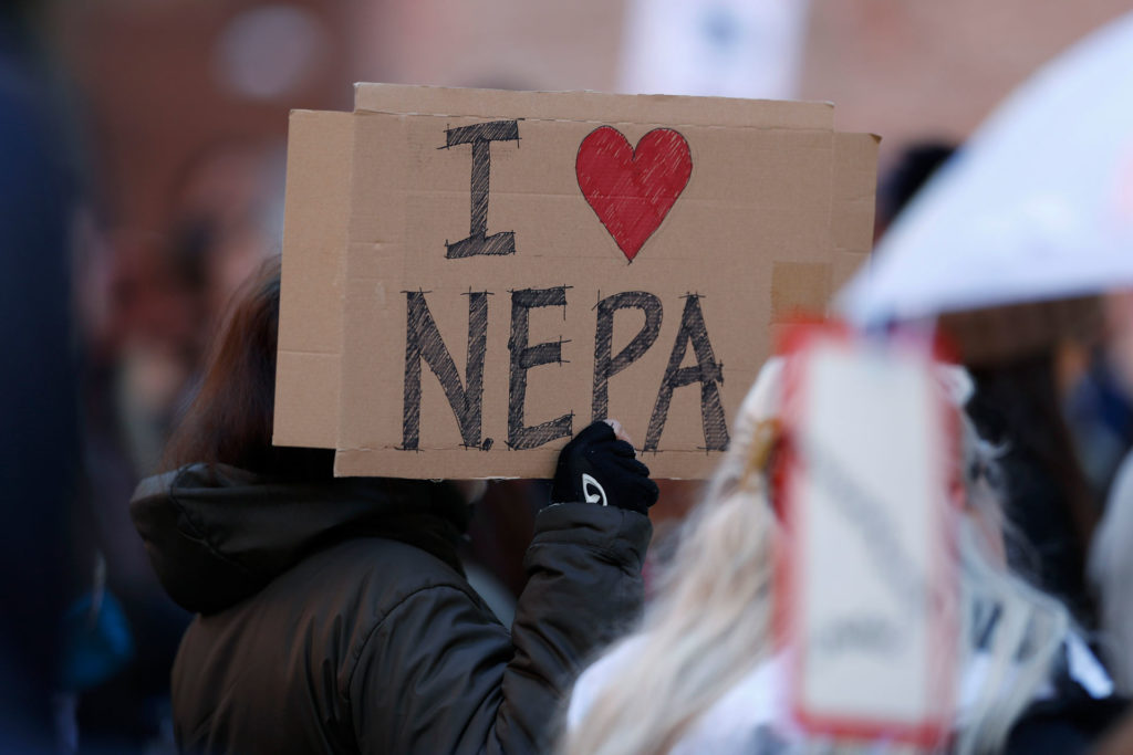 Joan Lutz waves a placard at a rally in Denver to voice support for the National Environmental Policy Act. (David Zalubowski, AP Photo)