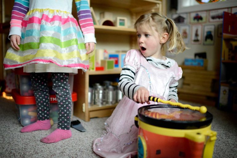 Iris Shook, 4, sings while Hannah Ringer, 4, looks on during play time at Rhiannon Shook's early childhood care program in Bozeman. (AP Photo, Rachel Leathe)